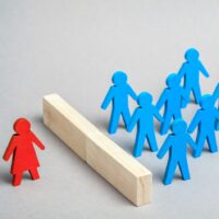 Gender discrimination of women at work and in society. Figures with men and one woman on a gray background Gender discrimination of women at work and in society. Figures with men and one woman on a gray background