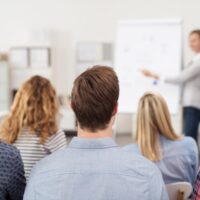 frau hält einen vortrag am flipchart vor einer gruppe