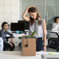 Upset female employee packing box getting fired from job