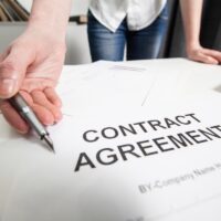 Business woman handing over a contract for signature offering at the office Business woman handing over a contract for signature offering at the office
